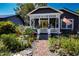 Inviting curb appeal with a gray exterior, covered porch, and a colorful front yard garden display at 1036 23Rd N Ave, St Petersburg, FL 33704