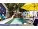 Inviting backyard pool with a natural stone waterfall feature, surrounded by lush tropical landscaping at 1036 23Rd N Ave, St Petersburg, FL 33704