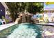 Sparkling pool with waterfall feature, ideal for relaxation, surrounded by stone pavers and lush tropical landscaping at 1036 23Rd N Ave, St Petersburg, FL 33704