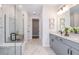 Modern bathroom featuring marble flooring, a glass-enclosed shower, and double vanity sinks with stylish fixtures at 10537 Longmeadow Ave, Parrish, FL 34219