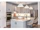 Modern kitchen featuring stainless steel appliances, white cabinets, a large island with quartz countertop at 10537 Longmeadow Ave, Parrish, FL 34219