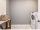 Well-lit laundry room featuring marble floors and new washer and dryer at 10537 Longmeadow Ave, Parrish, FL 34219