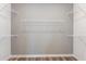 Walk-in closet with white shelving and hardwood floors to maximize space at 10537 Longmeadow Ave, Parrish, FL 34219