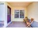 Charming front porch featuring a colorful door, window, brick flooring, and seating at 10928 Brickside Ct, Riverview, FL 33579