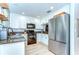 Bright kitchen featuring white cabinets, stainless steel appliances, and attractive granite countertops at 10928 Brickside Ct, Riverview, FL 33579