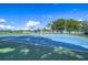 Inviting community tennis court with blue surface, green accents, and beautiful blue skies overhead at 10928 Brickside Ct, Riverview, FL 33579