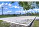 Bright, outdoor sand volleyball court on a clear day with green grass and beautiful blue skies overhead at 10928 Brickside Ct, Riverview, FL 33579