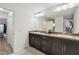 Well-lit bathroom with double vanity and sleek dark cabinets, adjacent to a hallway at 11165 Little Gull Rd, Weeki Wachee, FL 34614