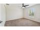 Bedroom with a ceiling fan, plush carpet, and natural light through a window at 11165 Little Gull Rd, Weeki Wachee, FL 34614