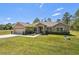 Traditional home featuring a manicured lawn, attached two car garage, and a covered front porch entry at 11165 Little Gull Rd, Weeki Wachee, FL 34614