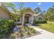 Home featuring covered entry framed by columns, front yard landscaping, and an ADT security system at 11165 Little Gull Rd, Weeki Wachee, FL 34614
