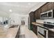 A kitchen featuring stainless steel appliances, tile floors, and dark wood cabinets at 11165 Little Gull Rd, Weeki Wachee, FL 34614