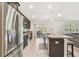 An island kitchen with an adjacent airy living room and stainless steel appliances at 11165 Little Gull Rd, Weeki Wachee, FL 34614