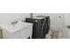 Well-equipped laundry room with modern washer and dryer, utility sink, and neutral finishes at 11165 Little Gull Rd, Weeki Wachee, FL 34614