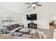 Cozy living room with a modern fireplace, plush seating, and a view into the bedroom at 11165 Little Gull Rd, Weeki Wachee, FL 34614