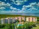 Stunning aerial view of waterfront condos with a pool, lush landscaping, and picturesque water views at 12033 Gandy N Blvd # 131, St Petersburg, FL 33702