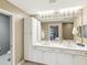 A bathroom with a double vanity, a large mirror, and white cabinetry at 12033 Gandy N Blvd # 131, St Petersburg, FL 33702