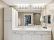 A bathroom with a double vanity, a large mirror, and white cabinetry at 12033 Gandy N Blvd # 131, St Petersburg, FL 33702
