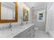 Bathroom featuring a double sink vanity with marble countertops and a shower at 12503 Bronco Dr, Tampa, FL 33626