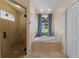 Bathroom featuring a shower with glass door and a soaking tub near a window at 12503 Bronco Dr, Tampa, FL 33626