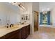 Bathroom featuring a double sink vanity, a walk in shower and a soaking tub at 12503 Bronco Dr, Tampa, FL 33626