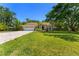 Single story home with well kept grass, landscaping, and a brick paved driveway leading to the garage at 12503 Bronco Dr, Tampa, FL 33626