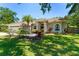 Landscaped front yard of a well maintained single story home featuring many windows and lovely plants at 12503 Bronco Dr, Tampa, FL 33626
