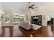 Open concept living room with dark hardwood floors, ceiling fan, and screened lanai access at 12503 Bronco Dr, Tampa, FL 33626