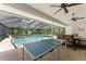 The screened-in patio features a pool, ping pong table, and a dining table for entertaining at 12503 Bronco Dr, Tampa, FL 33626
