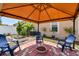 A backyard seating area with a brick patio, an orange gazebo, blue seating, and well maintained landscaping at 13312 Waterford Castle Dr, Dade City, FL 33525
