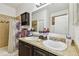 Well-lit bathroom featuring a double vanity, granite countertops, and tiled shower at 13312 Waterford Castle Dr, Dade City, FL 33525