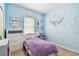 Bedroom features soft blue walls, natural light, a cozy bed, and modern furnishings at 13312 Waterford Castle Dr, Dade City, FL 33525