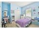 Bedroom with pastel blue walls, natural light, white bedroom set, and wood flooring at 13312 Waterford Castle Dr, Dade City, FL 33525