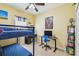 Shared bedroom with a blue bunk bed, black desk, yellow walls, and ceiling fan at 13312 Waterford Castle Dr, Dade City, FL 33525
