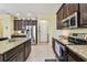 Gourmet kitchen boasting stainless steel appliances, granite counters, and dark wood cabinets at 13312 Waterford Castle Dr, Dade City, FL 33525