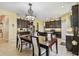 Dining and kitchen area boasts dark wood cabinets, granite counters, and stainless appliances at 13312 Waterford Castle Dr, Dade City, FL 33525