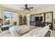Open-concept living room with a ceiling fan, large shelving unit, and sliding door to outside at 13312 Waterford Castle Dr, Dade City, FL 33525