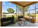 A screened patio with outdoor seating area and a view of the expansive backyard at 13312 Waterford Castle Dr, Dade City, FL 33525