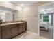 Bathroom featuring granite countertop with double vanity and dark cabinets at 13419 Willow Bluestar Loop, Riverview, FL 33579
