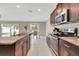 Gourmet kitchen featuring granite countertops, stainless steel appliances, and open access to the dining area at 13419 Willow Bluestar Loop, Riverview, FL 33579