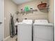 Laundry room featuring washer, dryer, storage shelf, and ironing board at 13419 Willow Bluestar Loop, Riverview, FL 33579