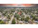 An aerial view showcases this home's location within a mature, tree-lined community near a serene pond at 1416 Murray Ave, Clearwater, FL 33755