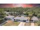 Aerial view of a single-story home with a fenced yard, mature trees, and a well-maintained lawn at 1416 Murray Ave, Clearwater, FL 33755