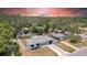 Aerial view of a single-story home with a fenced yard, mature trees, and a well-maintained lawn at 1416 Murray Ave, Clearwater, FL 33755