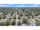 This aerial shows a single-story home nestled in a tranquil neighborhood with tree-lined streets near a serene lake at 1416 Murray Ave, Clearwater, FL 33755