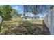 Wide view of the backyard featuring a privacy fence and lush greenery under a bright sky at 1416 Murray Ave, Clearwater, FL 33755