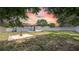 Cozy backyard setting featuring a concrete fountain, patio, and privacy fence under a colorful sunset sky at 1416 Murray Ave, Clearwater, FL 33755