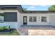 Charming home exterior featuring a well-kept lawn, brick pathway, and modern architectural details at 1416 Murray Ave, Clearwater, FL 33755