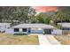 Beautifully renovated home with manicured lawn, modern exterior, and attached garage at 1416 Murray Ave, Clearwater, FL 33755
