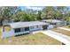 Beautifully renovated home with manicured lawn, modern exterior, and attached garage at 1416 Murray Ave, Clearwater, FL 33755
